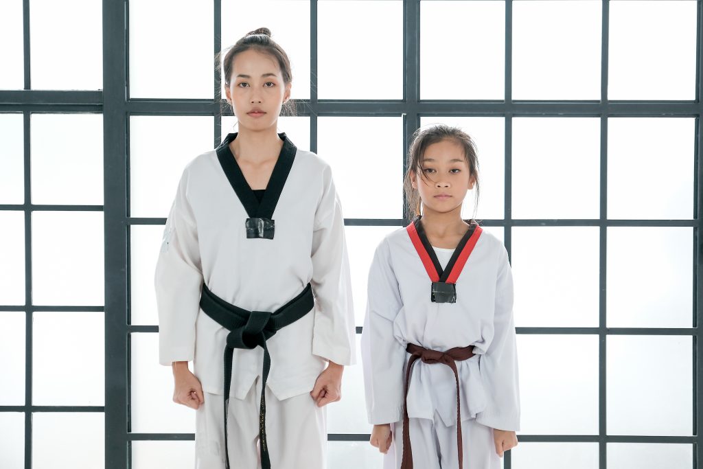 Asian Taekwondo teacher and student woman and girl stand for prepare of saluting